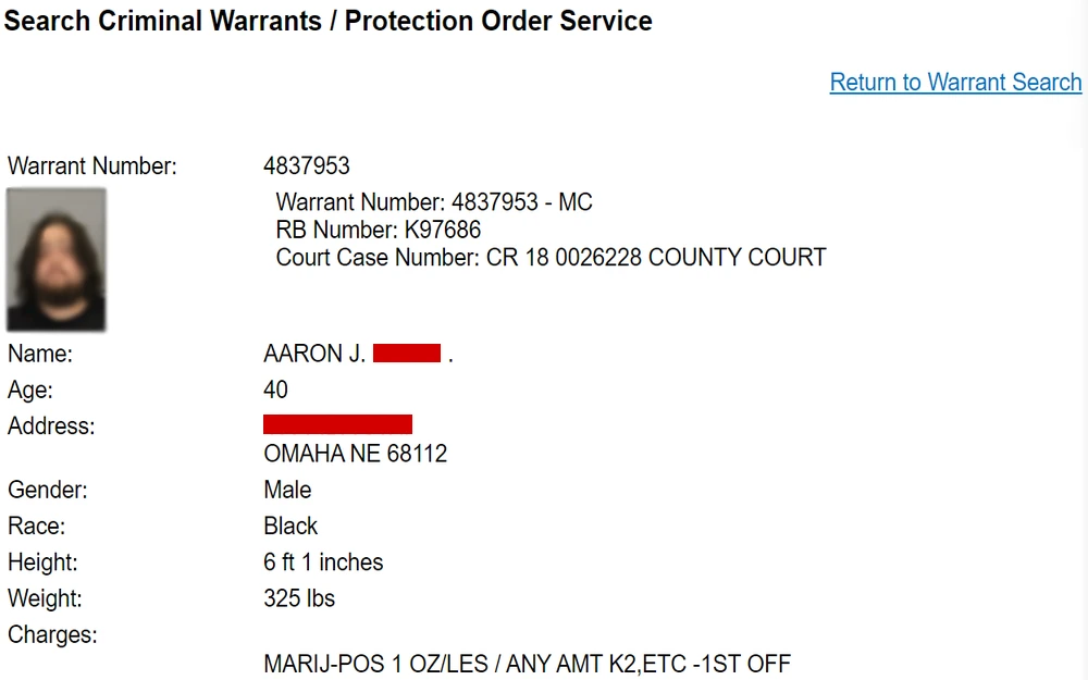 A screenshot from the Douglas County Sheriff’s Office displays detailed information for a warrant, including a photograph and personal details of a male individual, his physical description, and the specific charge under his name.